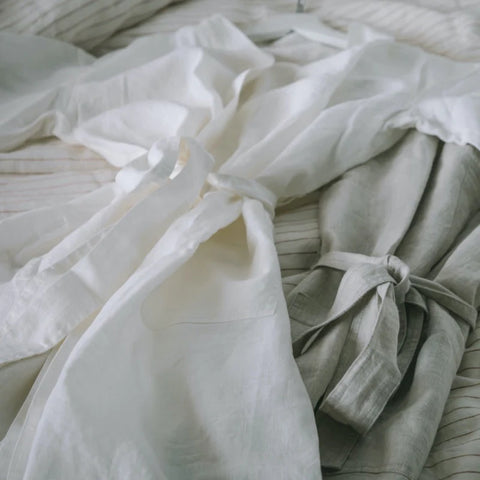 Luxurious European Flax Linen Robe in white and natural on a bed made with linen sheets