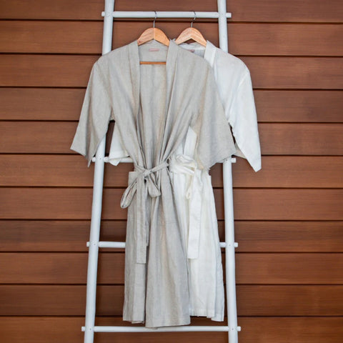 Luxurious European Flax Linen Robe in white and natural hanging on a wooden ladder in front of a wood panelling wall
