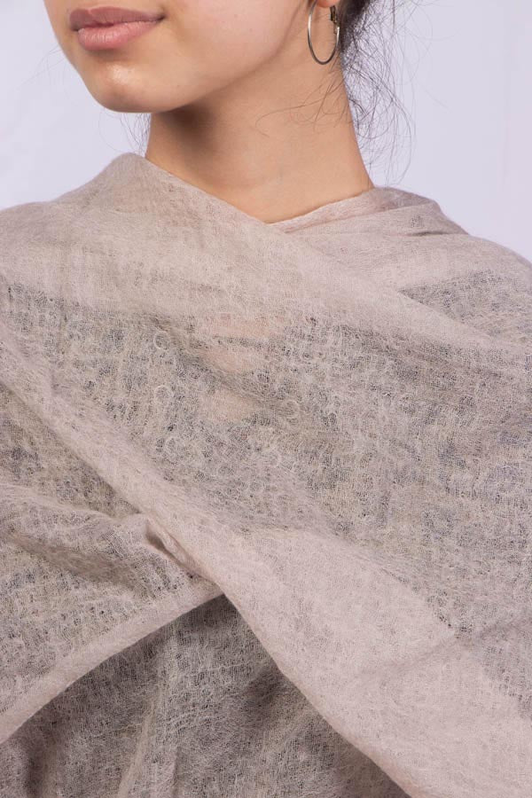 A female model displaying how to use a felted cashmere scarf as a wrap.