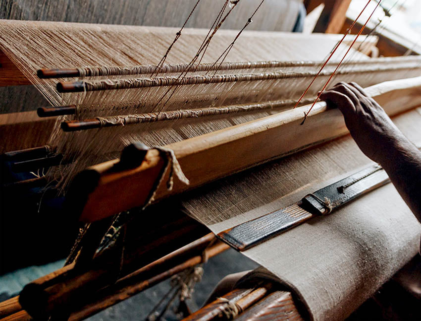 A person weaving cashmere scarf in a handloom.