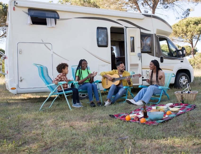 group of people playing guitar while picnic