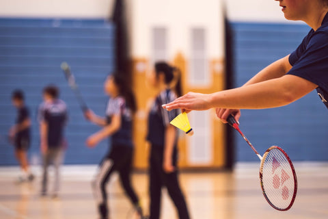 Badminton players warming up on the court
