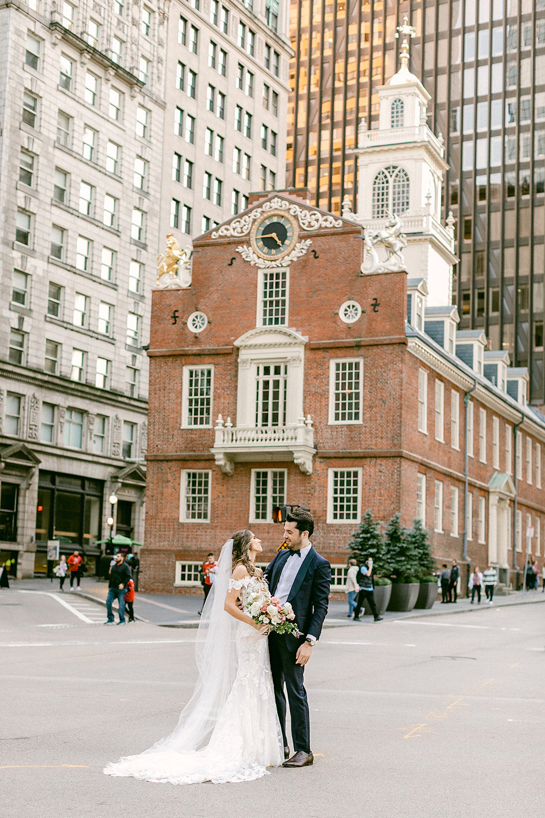 bride and groom embrace outside faneuil hall marketplace in downtown boston ma