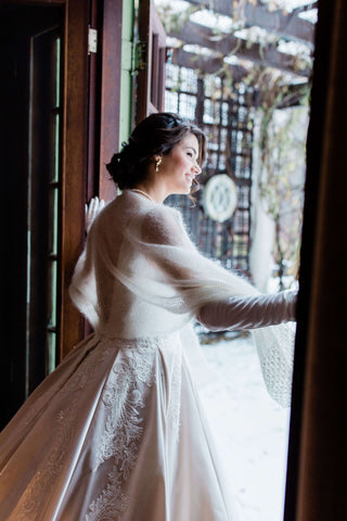 Bride looking out at winter scene from window in Willowdale Estate Topsfield, Massachusetts