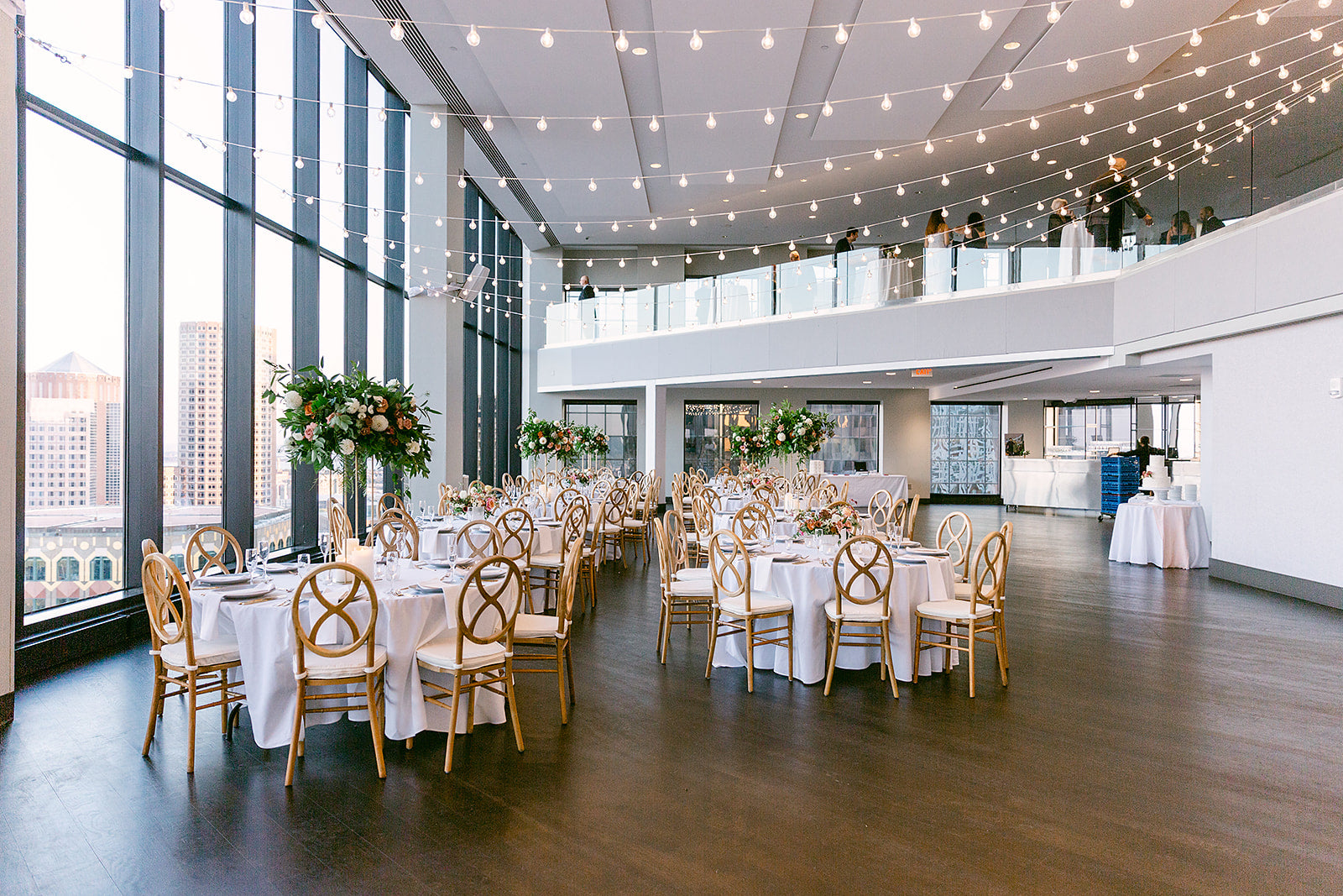 state room wedding venue with bistro lights and cross back chairs