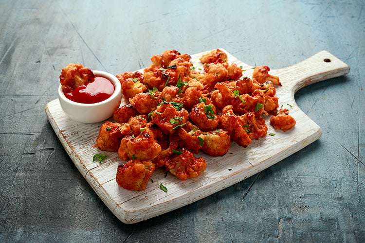 chicken wings on a cutting board with dipping sauce