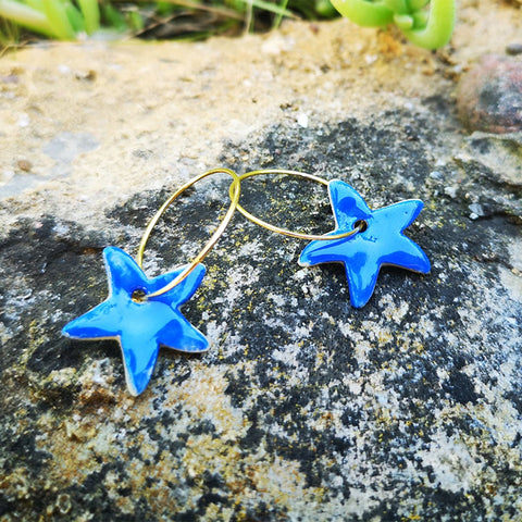 Boucles d'oreilles bleu Klein étoile pour femme et ado sur un rocher