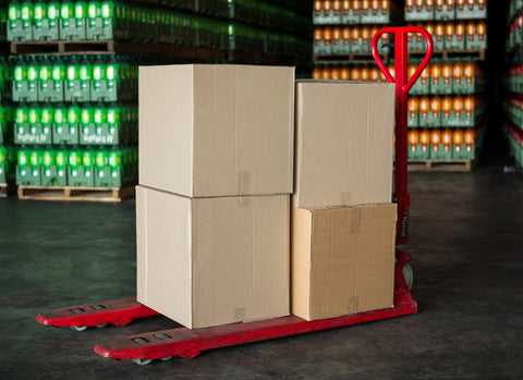 Stacked cardboard boxes on the hand pallet truck trolley in the industrial warehouse