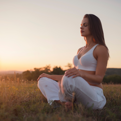 woman meditating in field