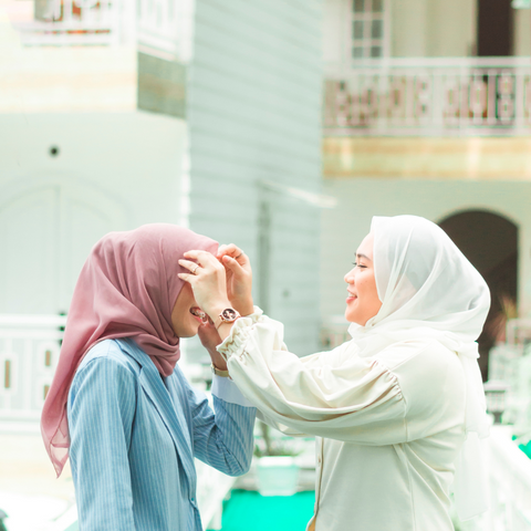 woman adjusting hijab of her friend