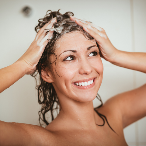 woman washing my hair and smiling to help cope with hair loss
