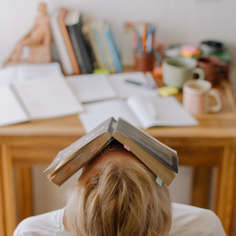 woman with a book on her face, stressed