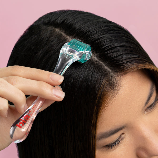 person using derma roller on their scalp