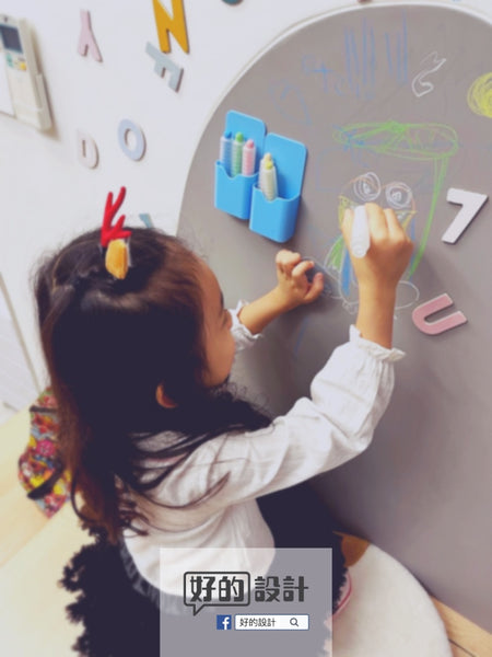 A little girl drawing and doodling on the wall at home