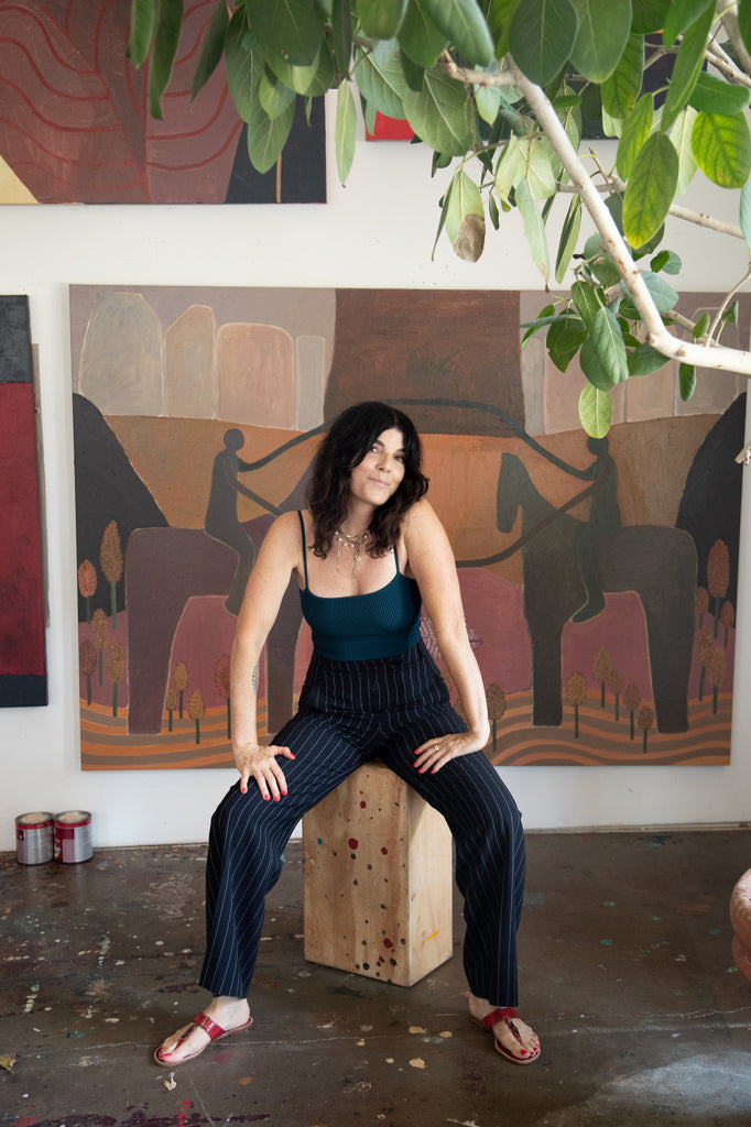 artist alexandra valenti in her east austin studio with paintings