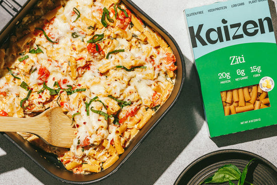 Feta air fryer pasta bake in the air fryer basket with a box of Kaizen lupini bean pasta.