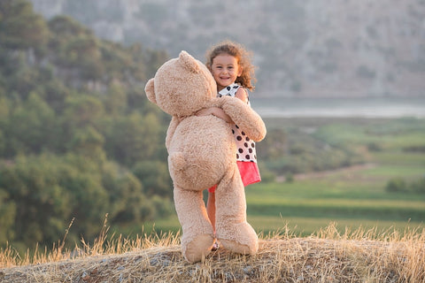 Câlin d'un enfant avec un ours en peluche géant