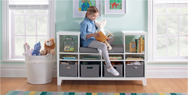 Imagen de una niña sentada y leyendo en el rincón de lectura para niños de Martha Stewart Living and Learning.