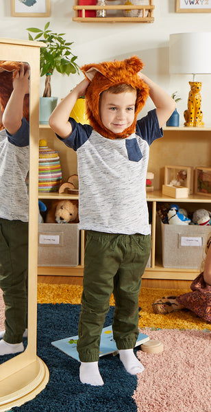 Image of a preschool-aged boy wearing an animal costume from the Guidecraft rotating dress up costume storage center.