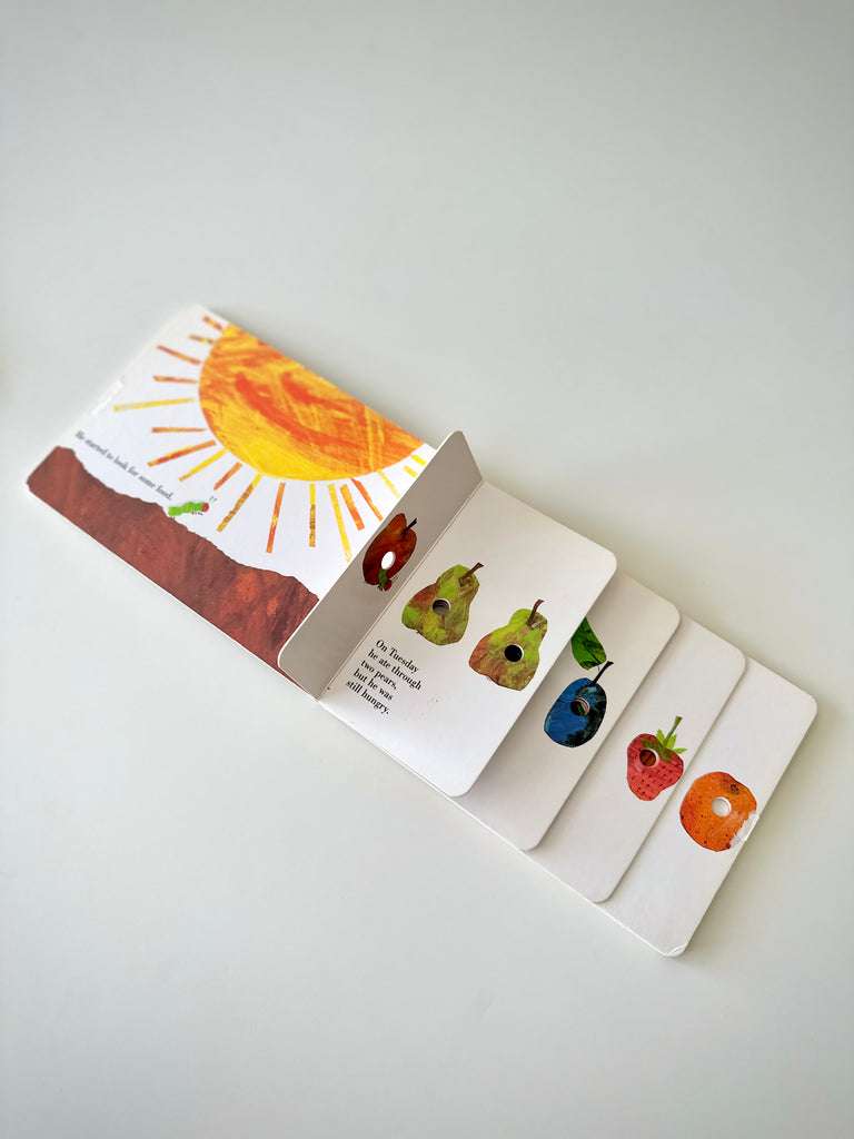 Eric Carle's "The Very Hungry Caterpillar" has open holes on eacg food item that can be touched while counting.