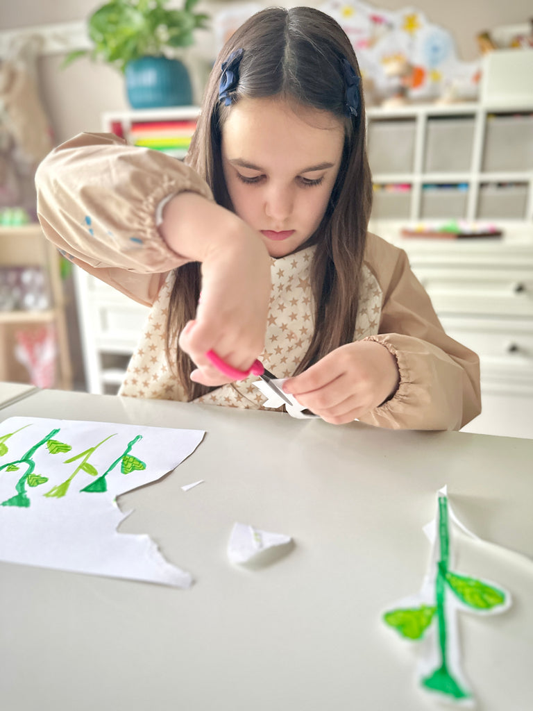 Girl using scissors to cut out draw flower stems