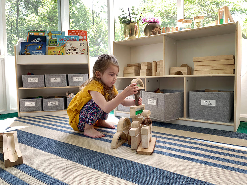 Image of young girl building with sensory blocks with EdQ Essentials toy and book storage