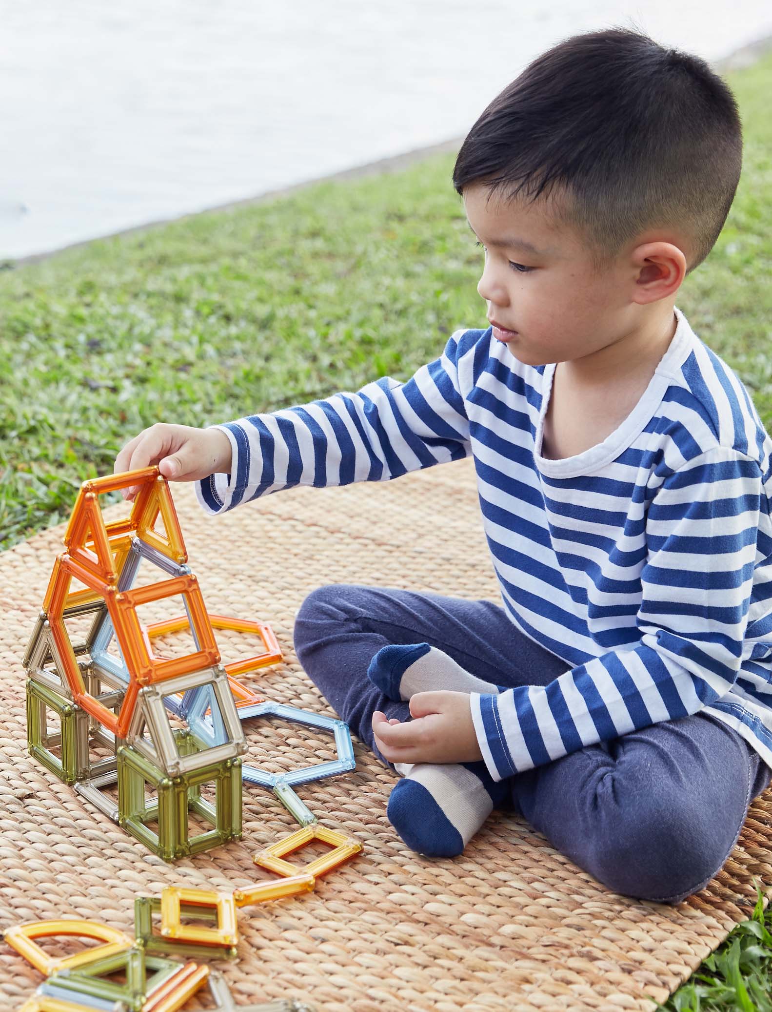 Kid outside playing with magnetic blocks