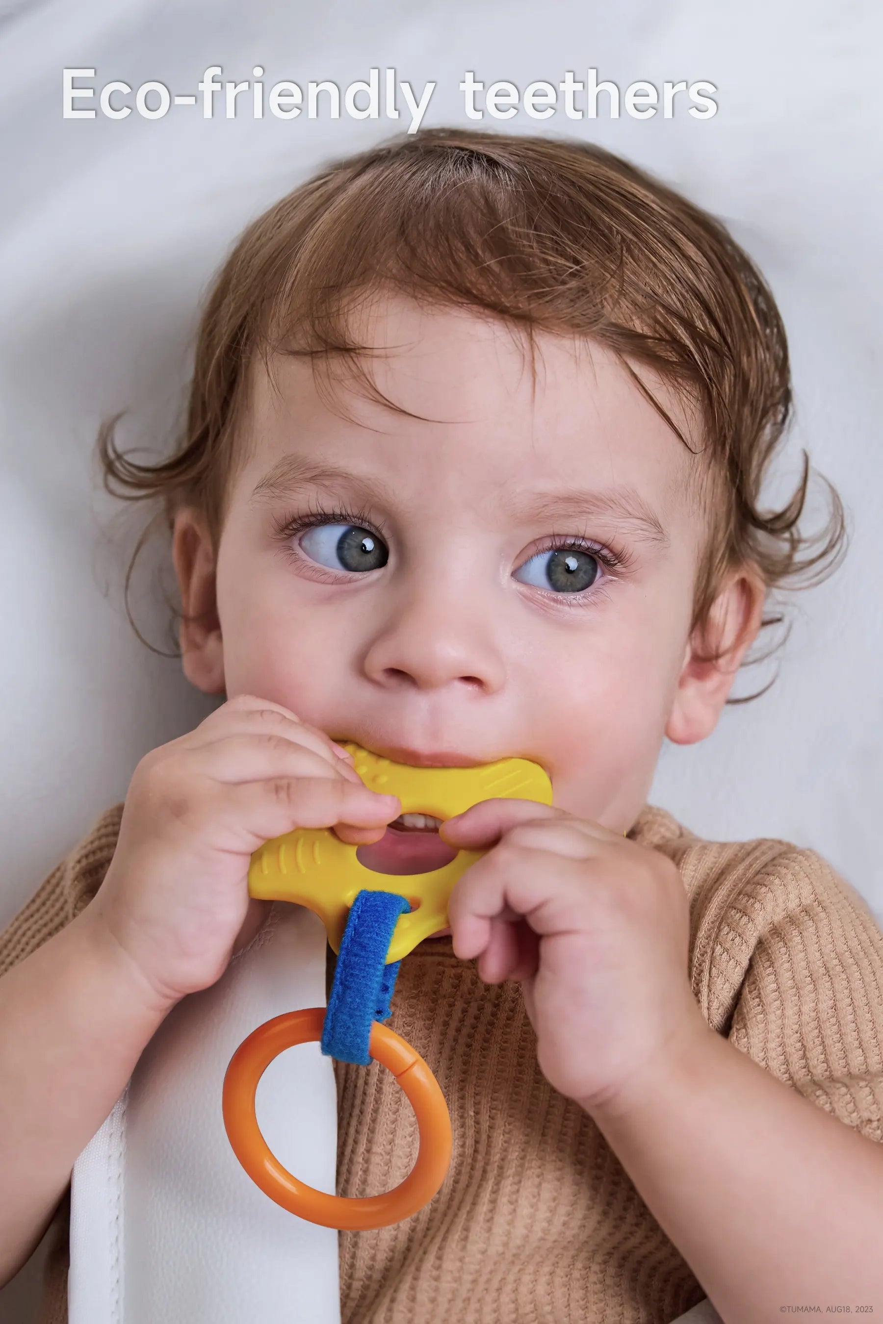 A baby chewing on a koala giraffe parrot stroller arch toy