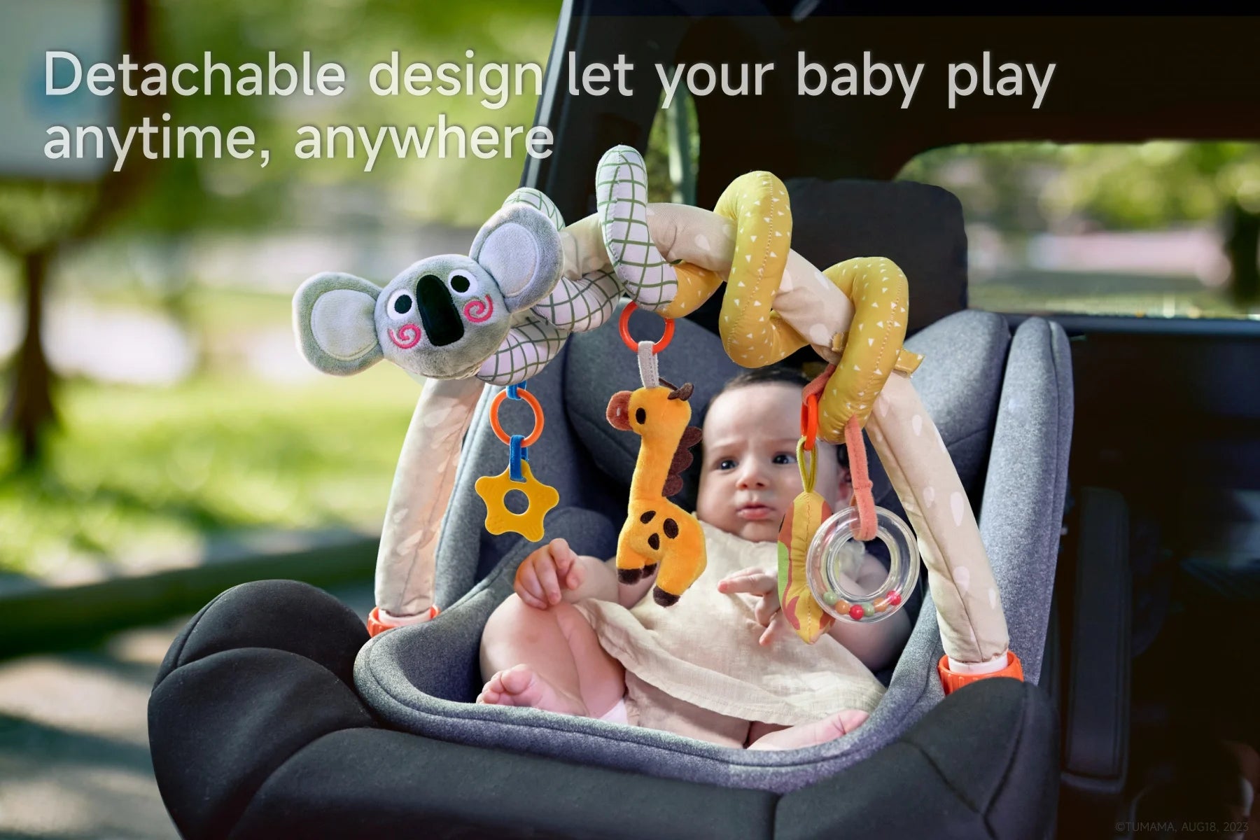 A baby playing with an arch toy in a car