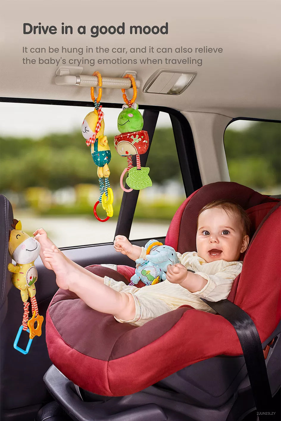 A baby sitting in a car looking at a frog lion toy hanging from the car