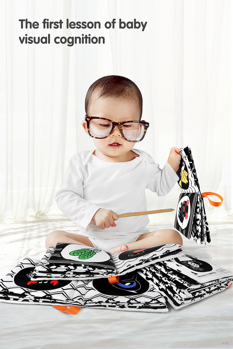 A baby with glasses playing with black and white crinkle book soft cloth baby book toy