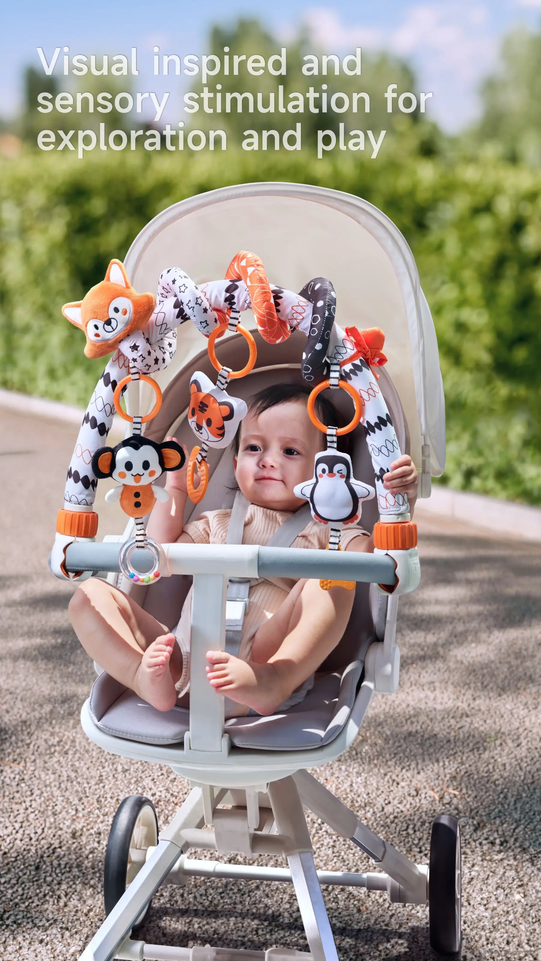 baby in a stroller with high-contrast animal toys (fox, tiger, penguin) attached to an arch for visual and sensory stimulation.