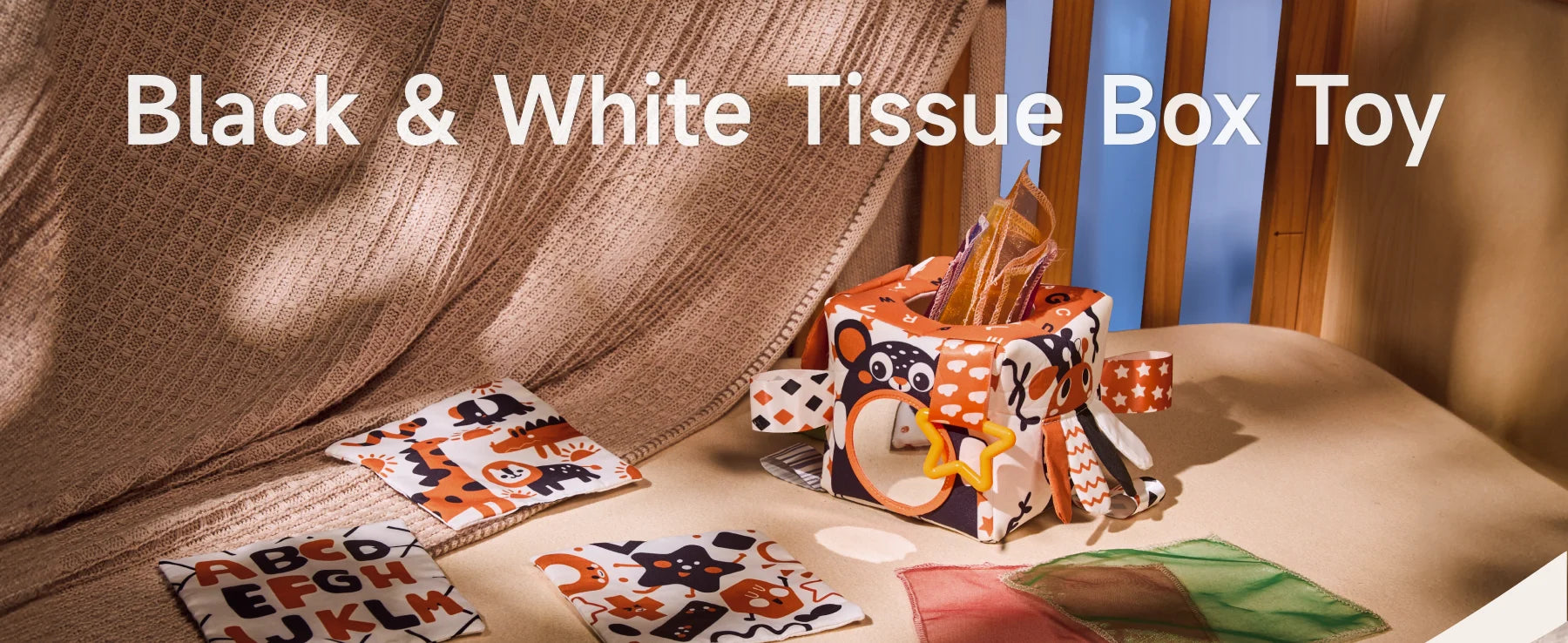Black and white sensory tissue box toy with high-contrast learning cards and colorful ribbons for baby visual development and Montessori play