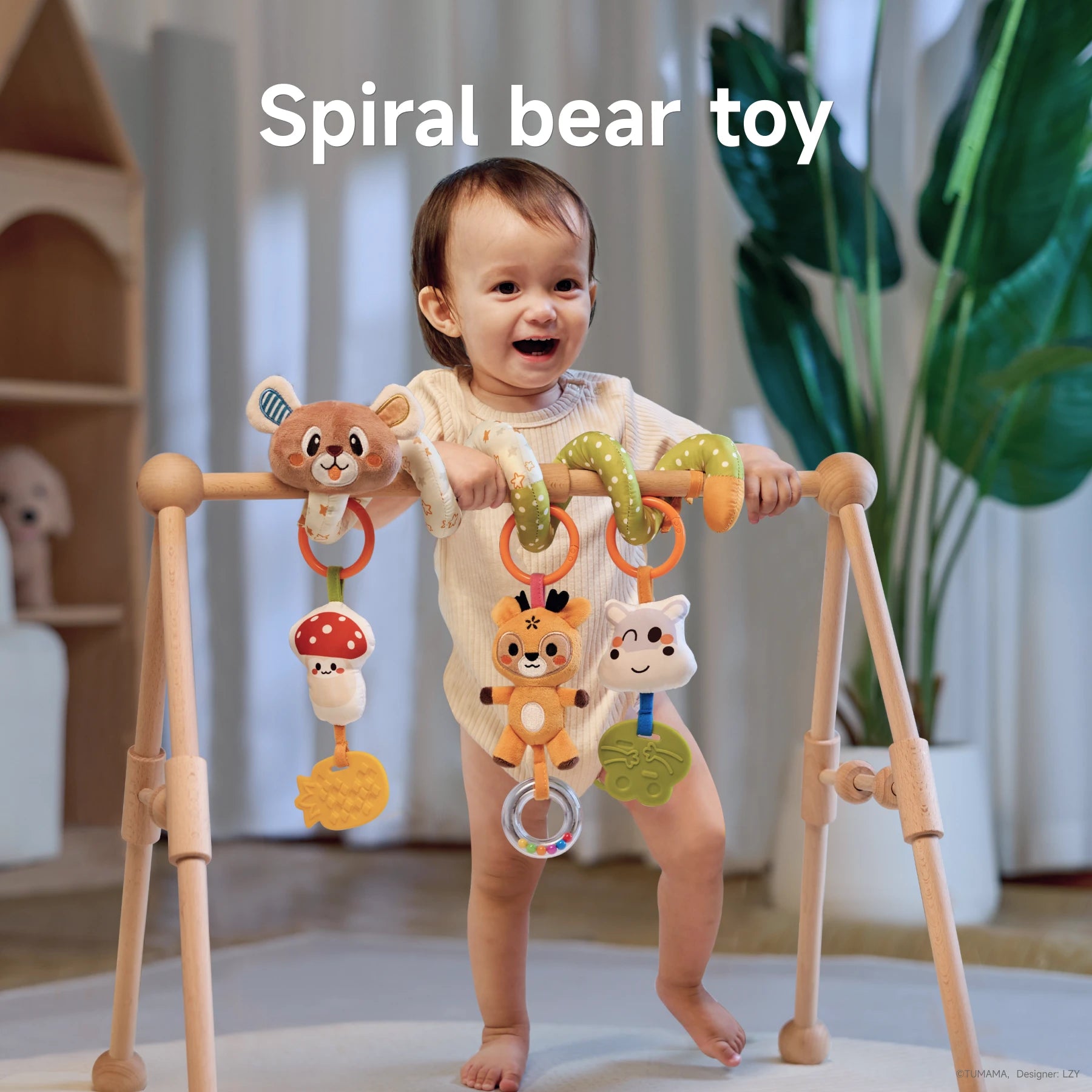 A baby standing and holding onto a wooden play gym, enjoying the spiral bear toy. The toy features a plush bear, mushroom, pineapple teether, and bead rattle, securely wrapped around the play gym bar for interactive and sensory play.