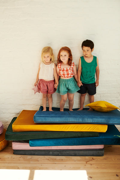 trójka dzieci stojących na materacach welurowych od bettys home dekoracja pokoju bliźniaków