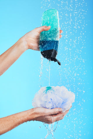 Pouring shower gel onto a Loofah in the shower