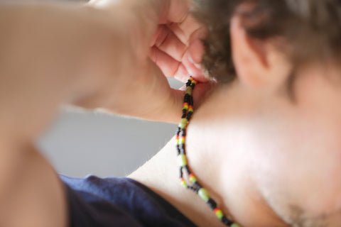 Young adult putting on a neck chain