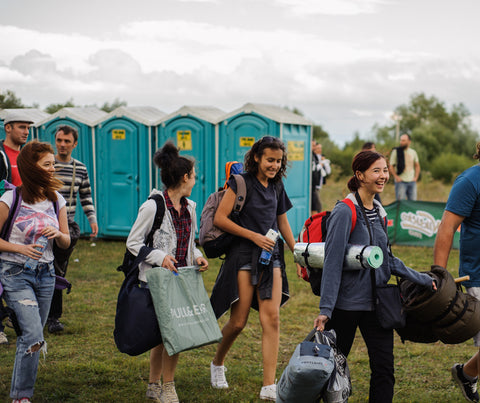 Young adults walking in a field at a Music festival