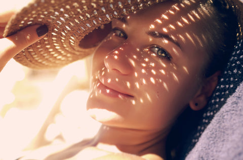 Teenage girl under a sun hat lying in the sun
