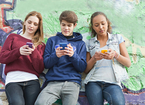 three teens on phones