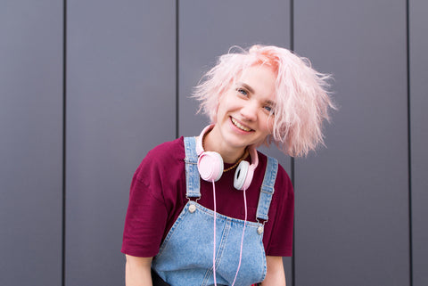 Young adult woman with pink hair smiling