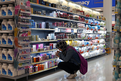 Teenager looking carefully at cosmetic product in a store