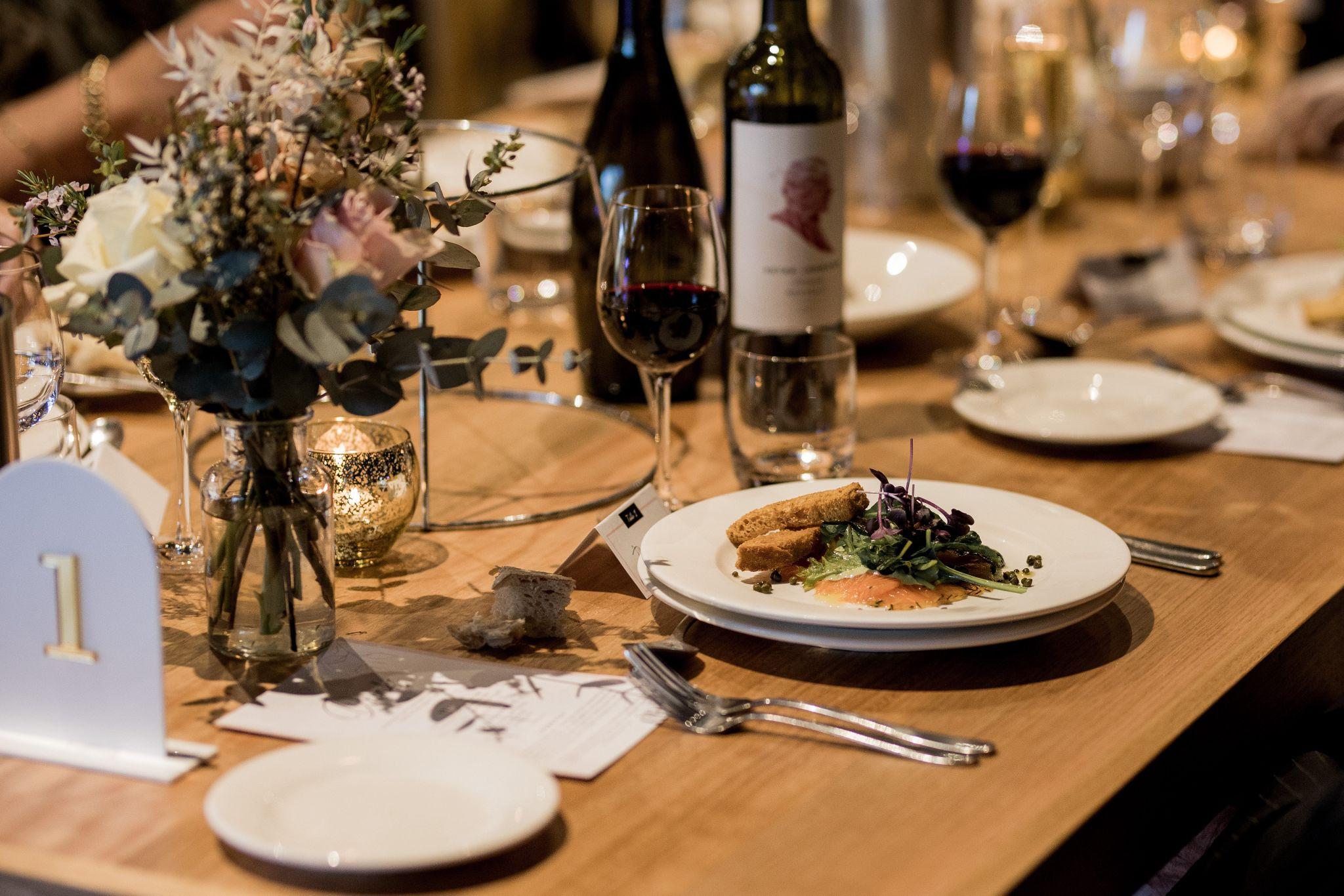 Food and wine laid out at the table of Jenna and Hayden’s wedding reception at Peter Lehmann’s vineyard. 