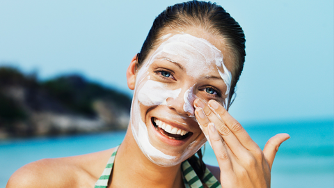 A girl applies sun protection creams 