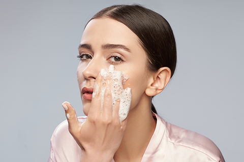 A girl uses a gentle cleanser to prevent dry skin