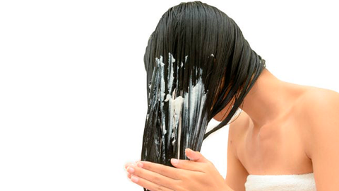 Girl uses hair conditioner to get healthy hair 