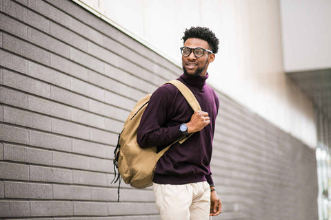 Man with a burgundy turtleneck wearing a backpack