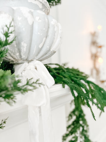 Vintage urn with velvet ribbon and Christmas greenery