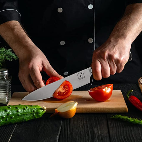 Chef slicing a tomato with a sharp knife