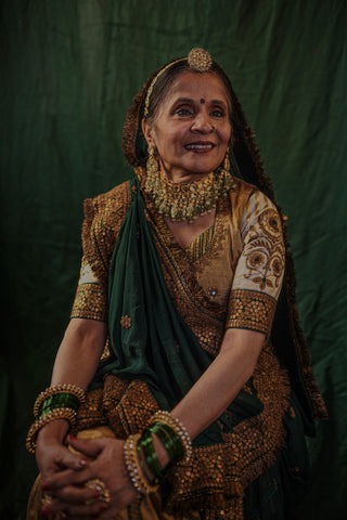 Ashaji , the bride's mother dressed in a beautiful golden lengha made by designer Ayush Kejriwal.